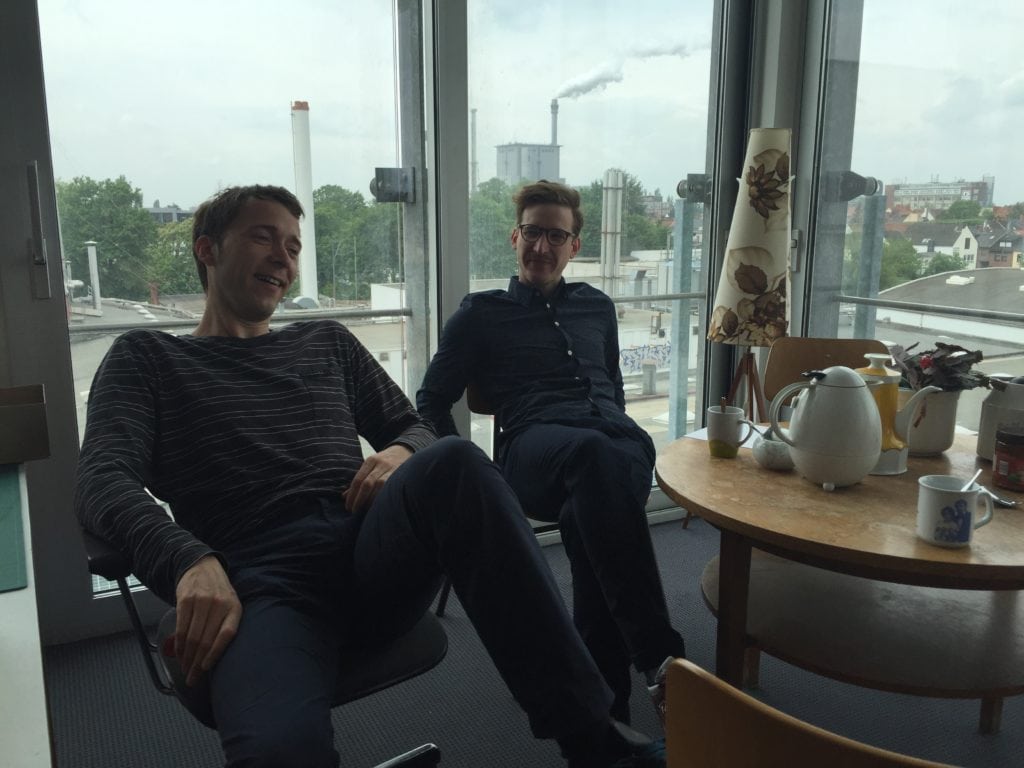 Zwei Männer sitzen am Kaffeetisch