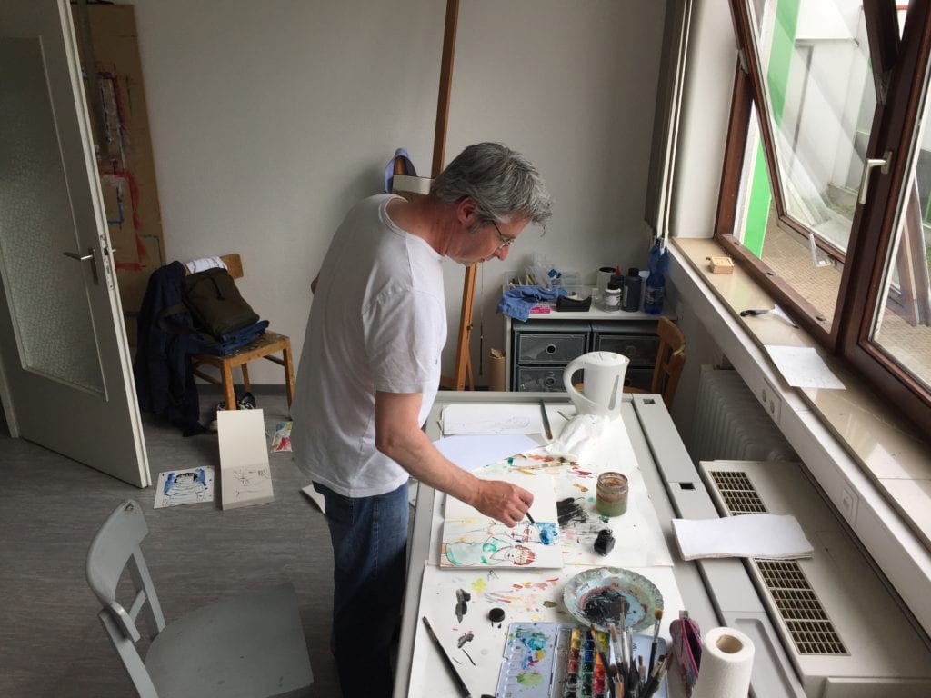 Künstler arbeitet an einem Tisch im Atelier