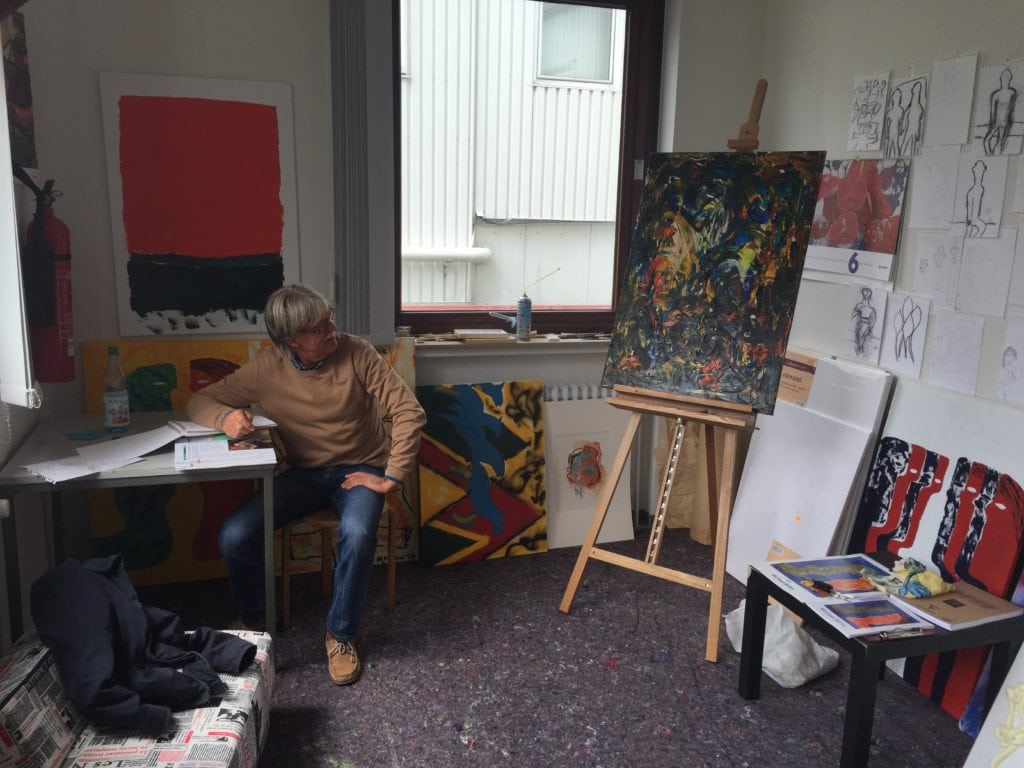 Künstler im Atelier zwischen Leinwänden